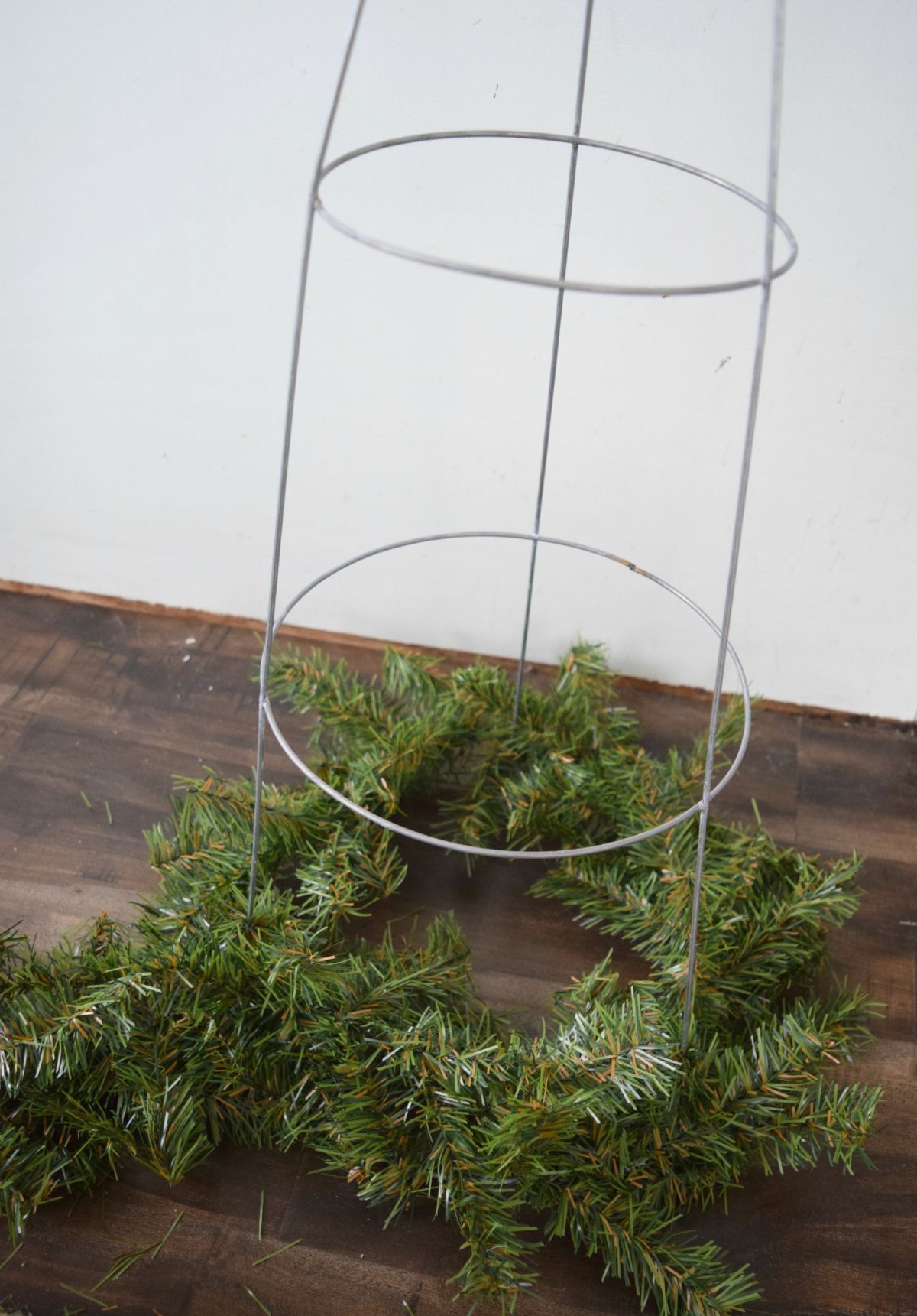 Adding garland to tomatoe cage